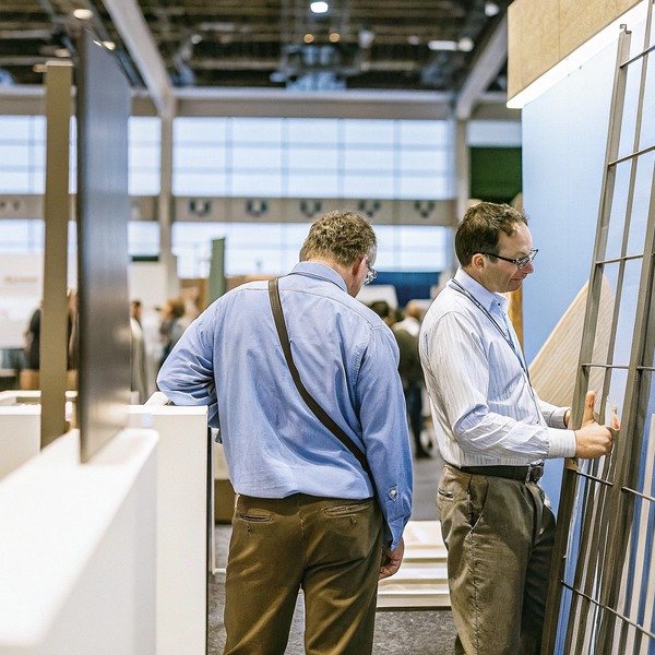 Two men examining display at trade show (ID#1)