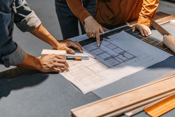 Team reviewing architectural blueprint plans (ID#2)