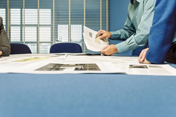 People reviewing documents in office meeting (ID#2)