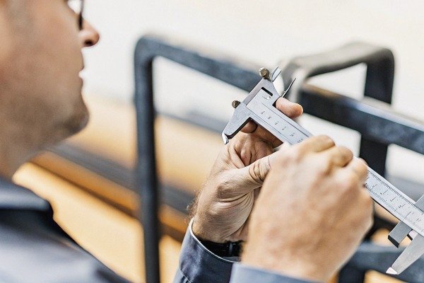 Man measuring metal part with caliper tool (ID#5)