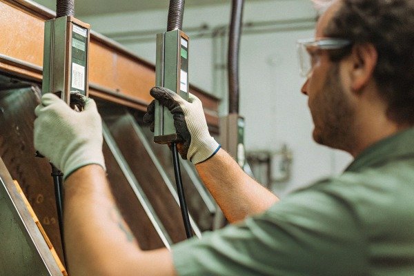 Technician using measurement instruments on metal structure (ID#3)