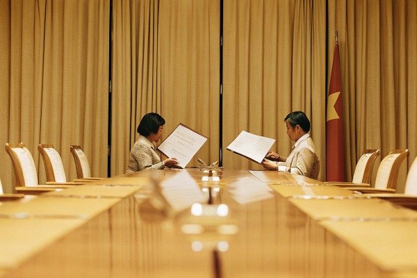 Two people reading documents in conference room (ID#2)
