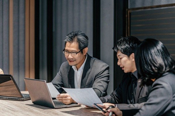 Business team discussing documents at meeting (ID#5)