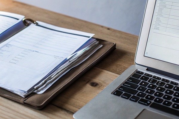 Documents and laptop on wooden desk (ID#3)