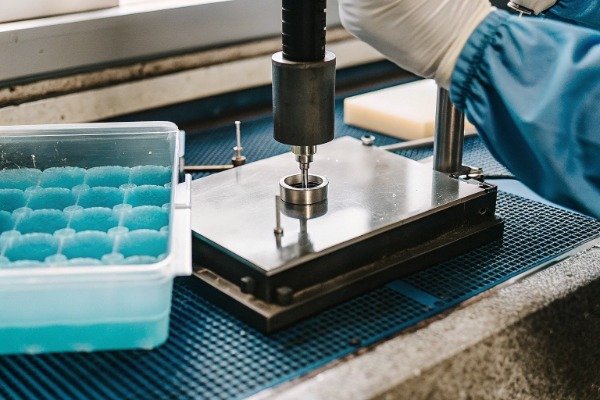 Technician performing inline leak test and material analysis (ID#4)