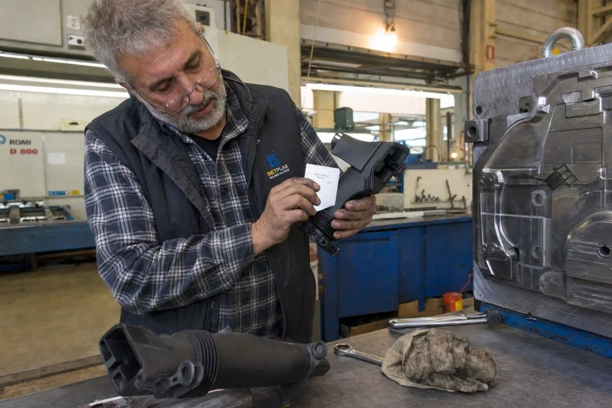 Technician inspecting mold tooling insert to eliminate undercuts in part geometry (ID#5)